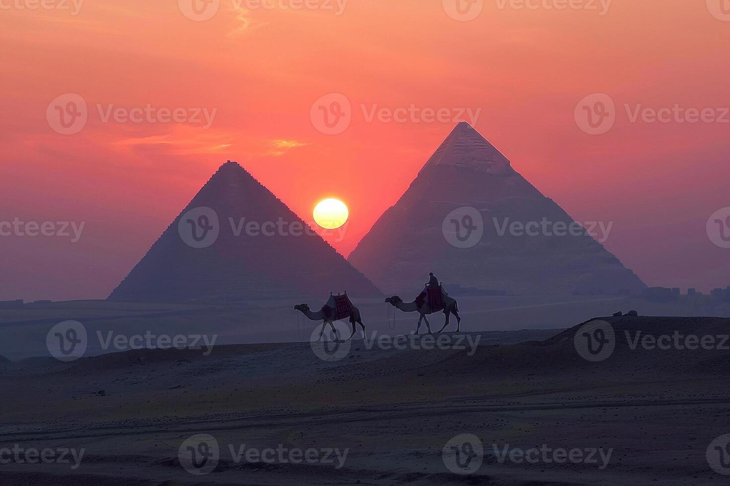 Caravan crossing the desert with ancient pyramids in background at sunset photo
