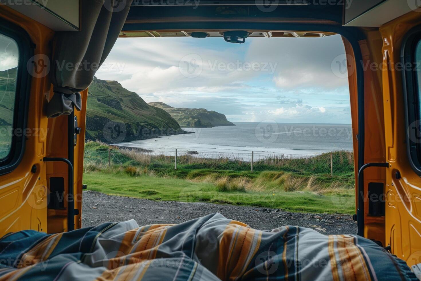Waking up in a camper van with a view of the ocean and green hills photo