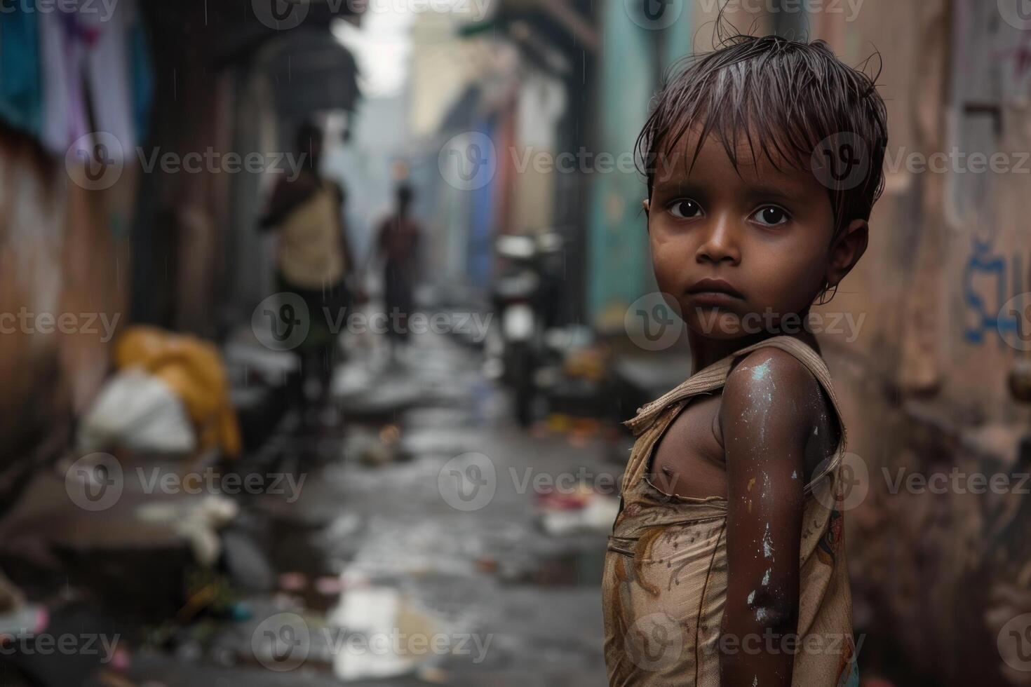 Young boy standing in a poverty stricken street in india photo