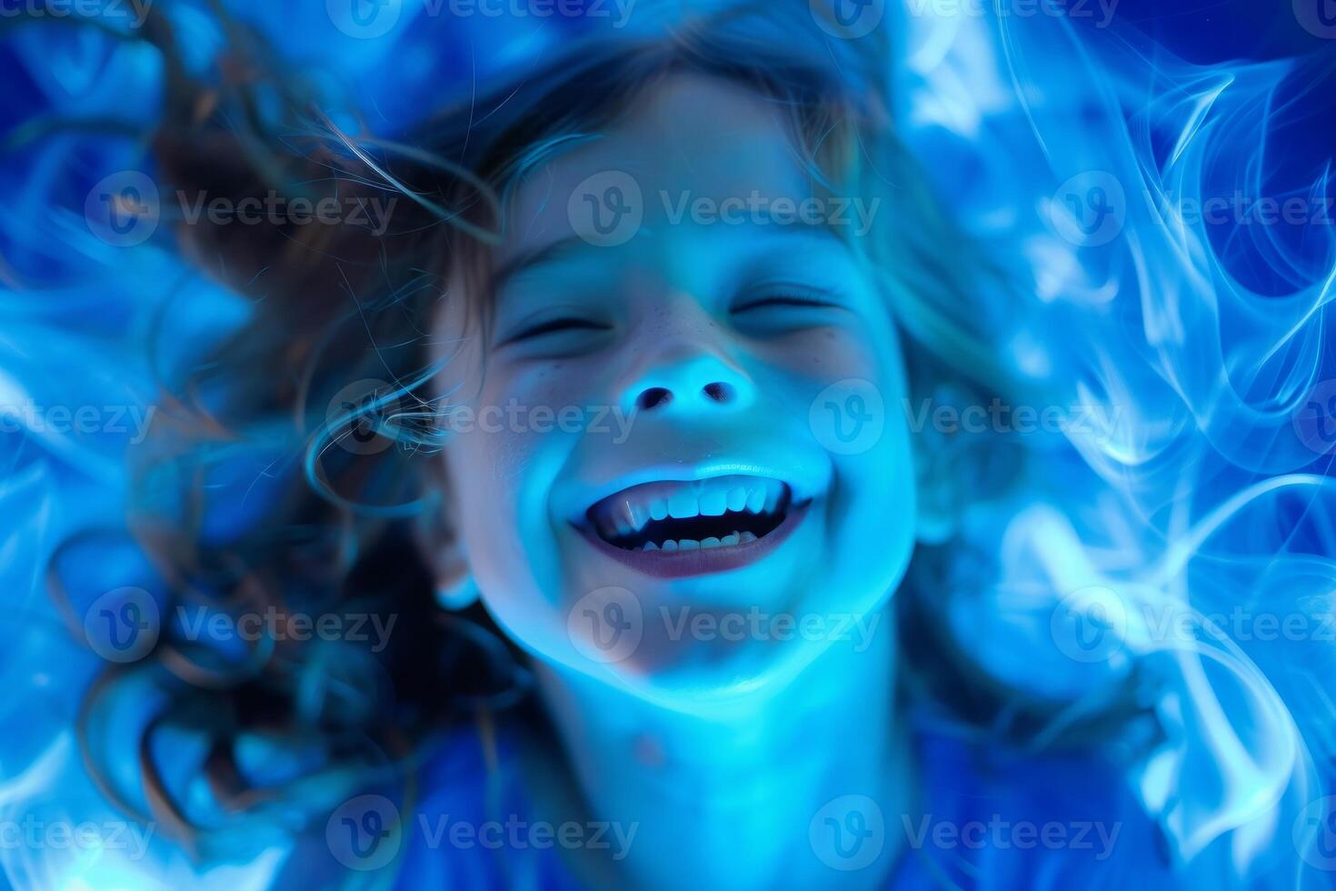 Overhead view of a cheerful young girl swimming, surrounded by ripples of water photo