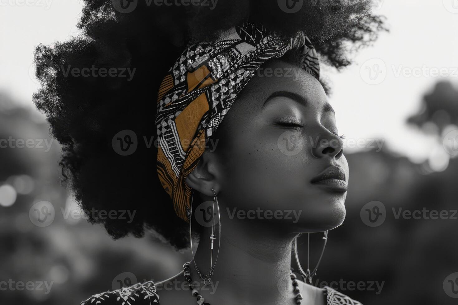 Peaceful portrait of a woman with an afro and headscarf in black and white tones photo