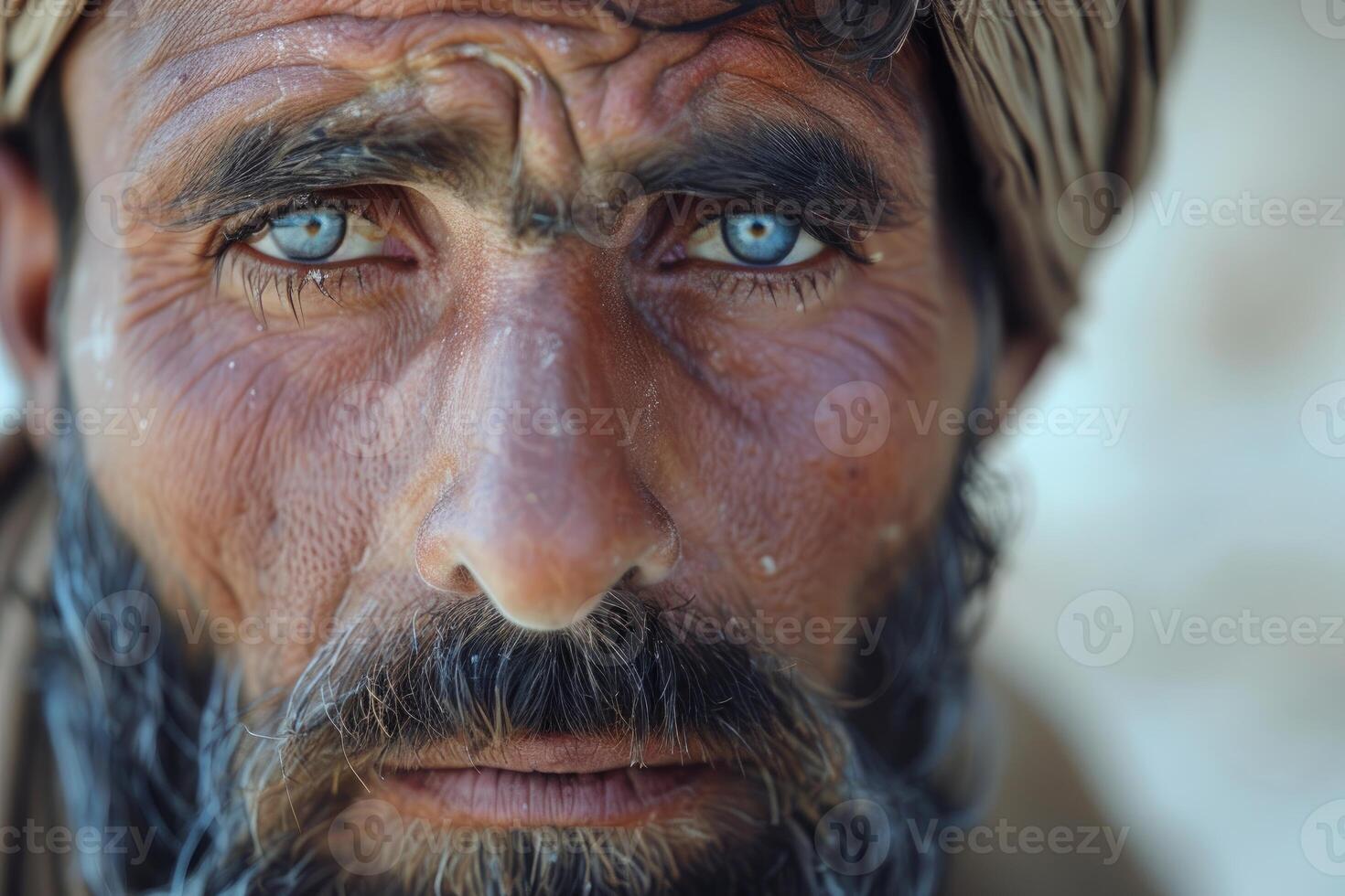 Intense gaze of a bearded man with piercing blue eyes photo