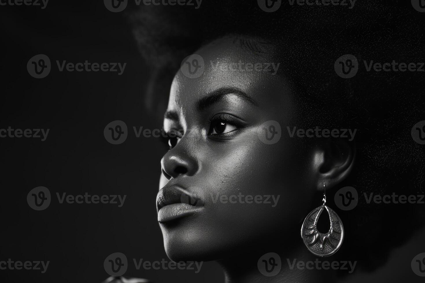 A side profile of a woman with striking features, illuminated in black and white photo