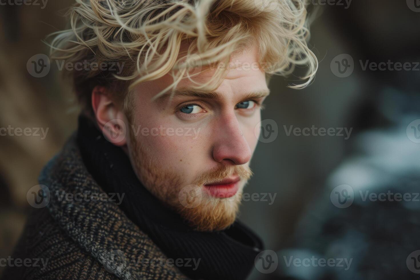Handsome blond man in winter attire looking thoughtful photo