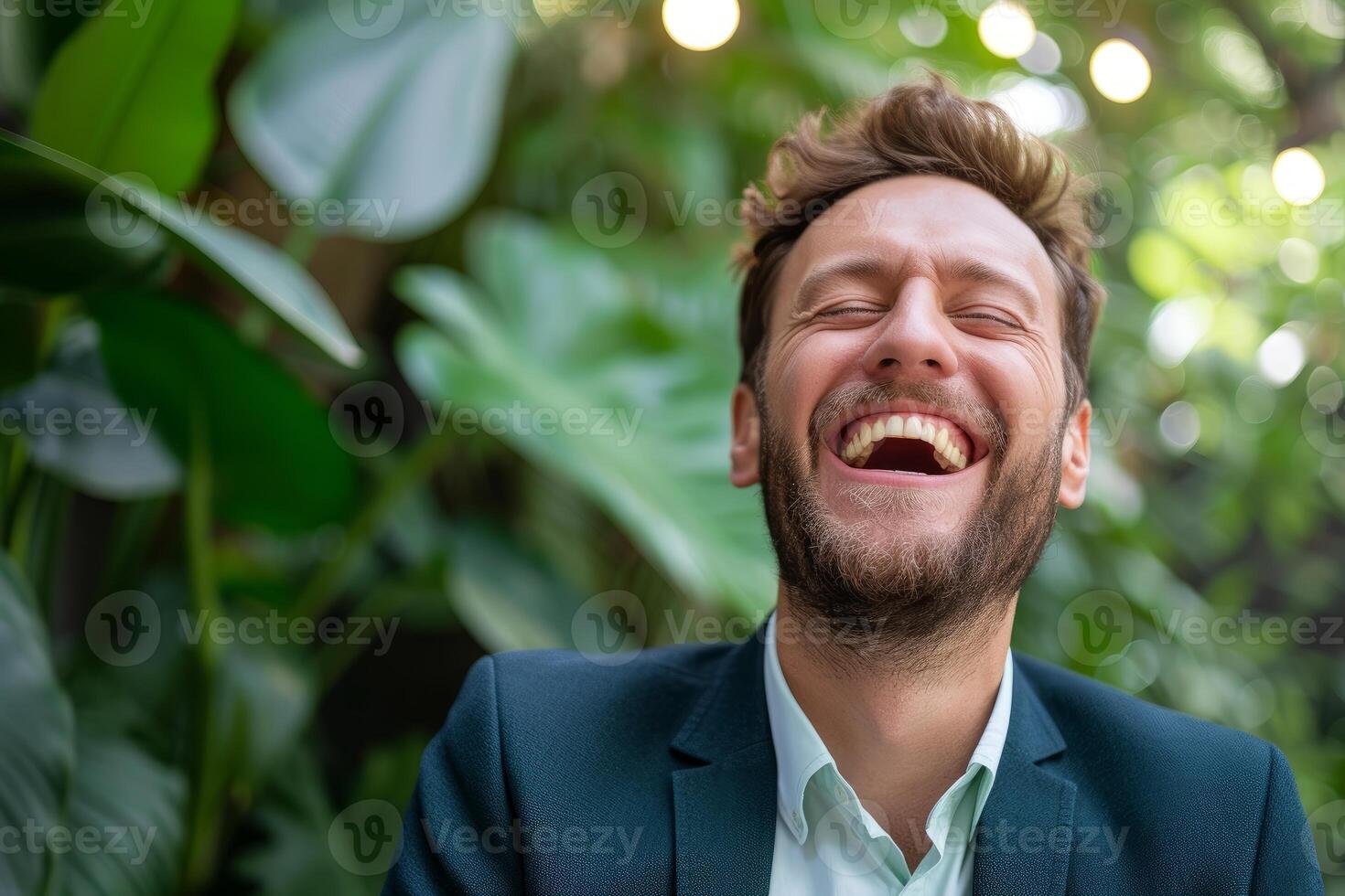 Close-up of a happy bearded man in a suit laughing with a nature background photo