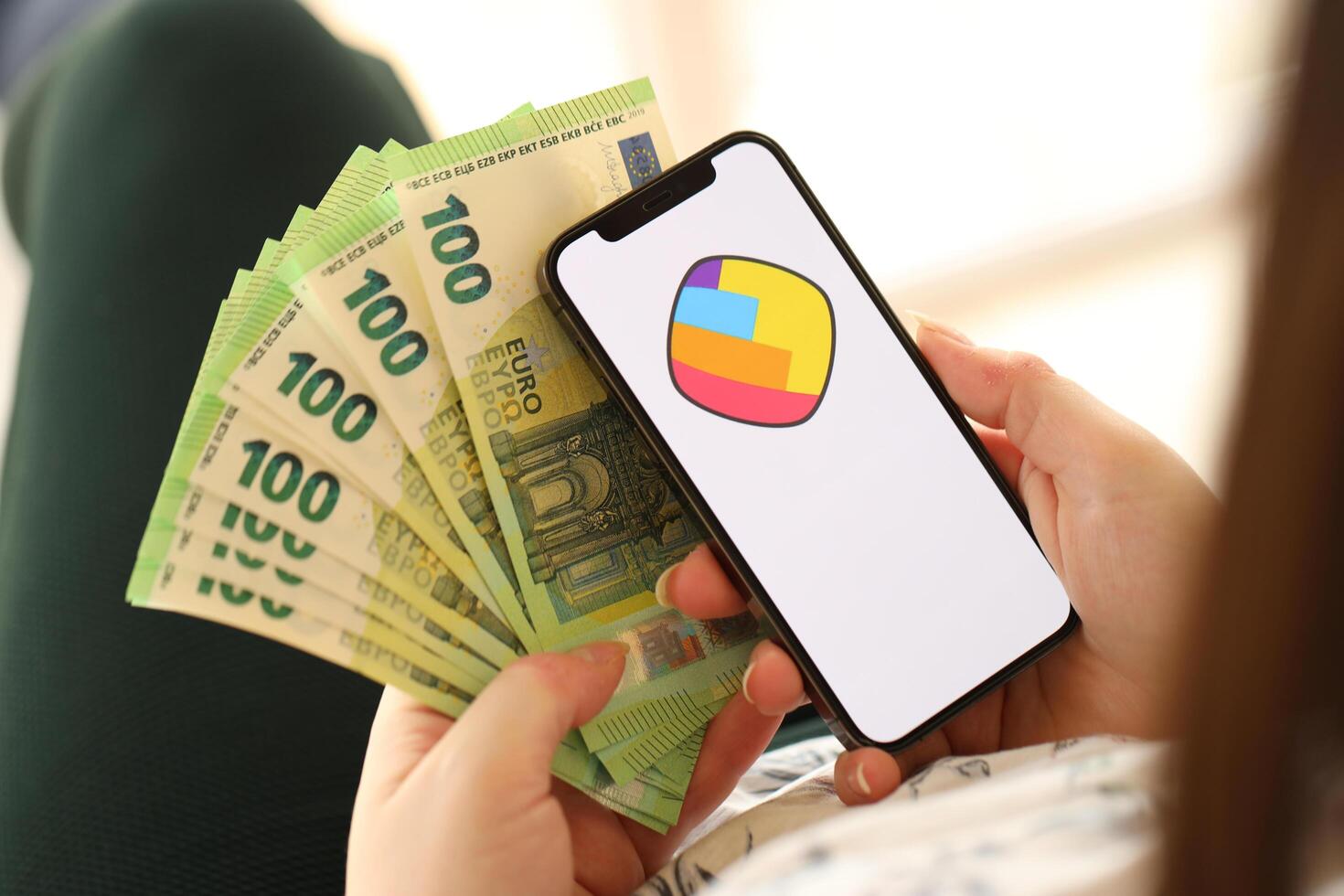 KYIV, UKRAINE - APRIL 1, 2024 Sharechat icon on smartphone screen and money in female hand photo