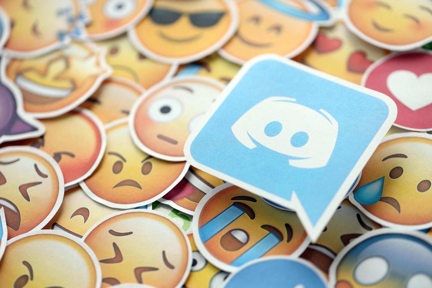 KYIV, UKRAINE - APRIL 20, 2024 Discord logo and large set of stickers with Emoji yellow faces. Emoji is a pictogram or smiley embedded in text and used in electronic messages photo