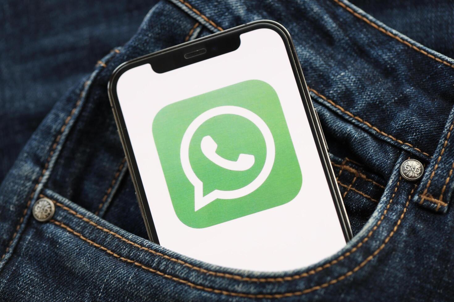 KYIV, UKRAINE - APRIL 1, 2024 Whatsapp messenger icon on smartphone display screen in jeans pocket photo