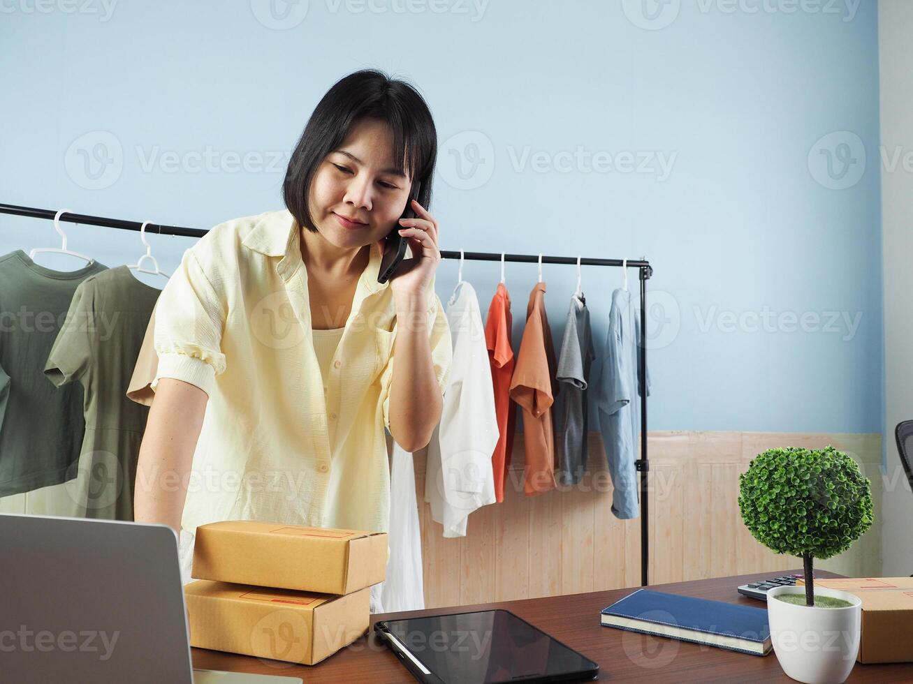 a woman is talking on the phone while sitting at a desk photo