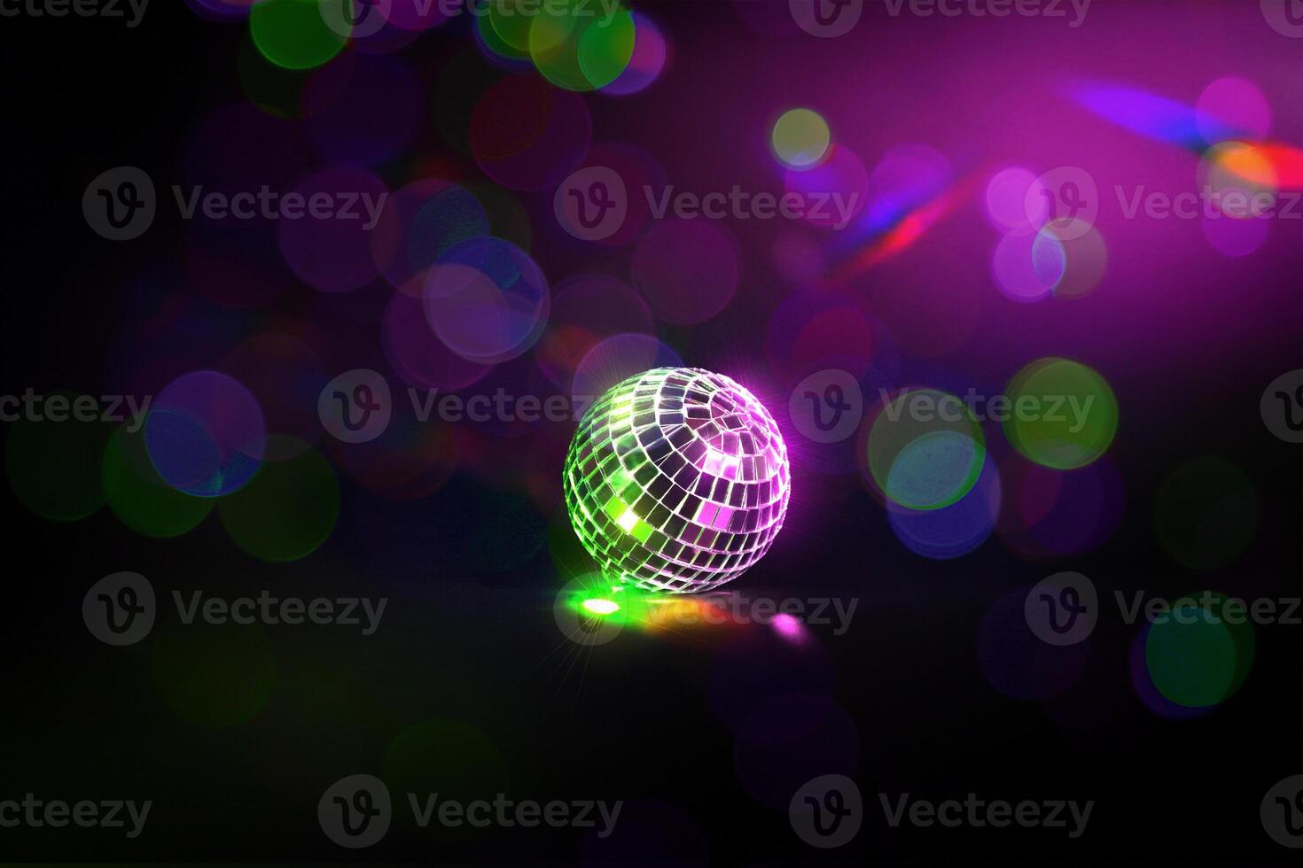 Disco ball on black background with neon light photo