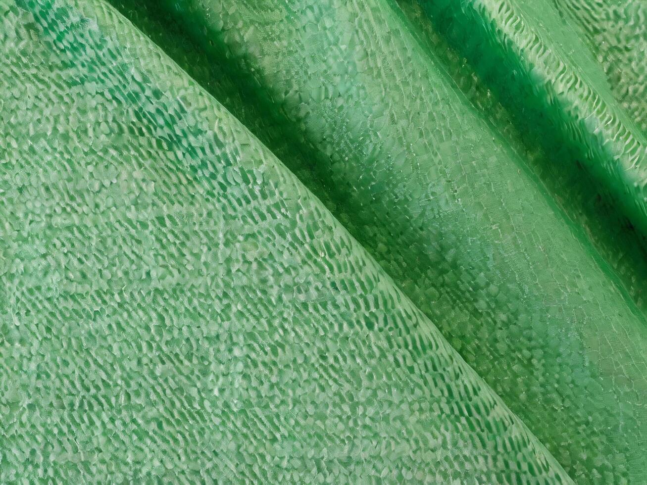 Texture, background, pattern. Texture of green silk fabric. Beautiful emerald green soft silk fabric. photo