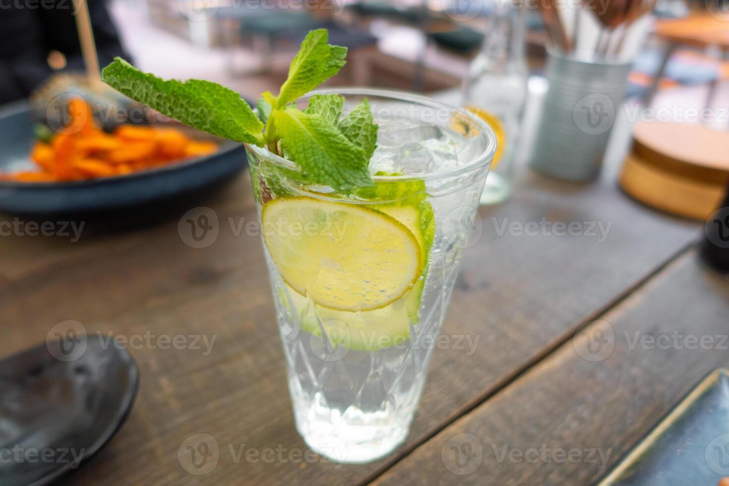 Lemonade with fresh lemon on wooden table background photo