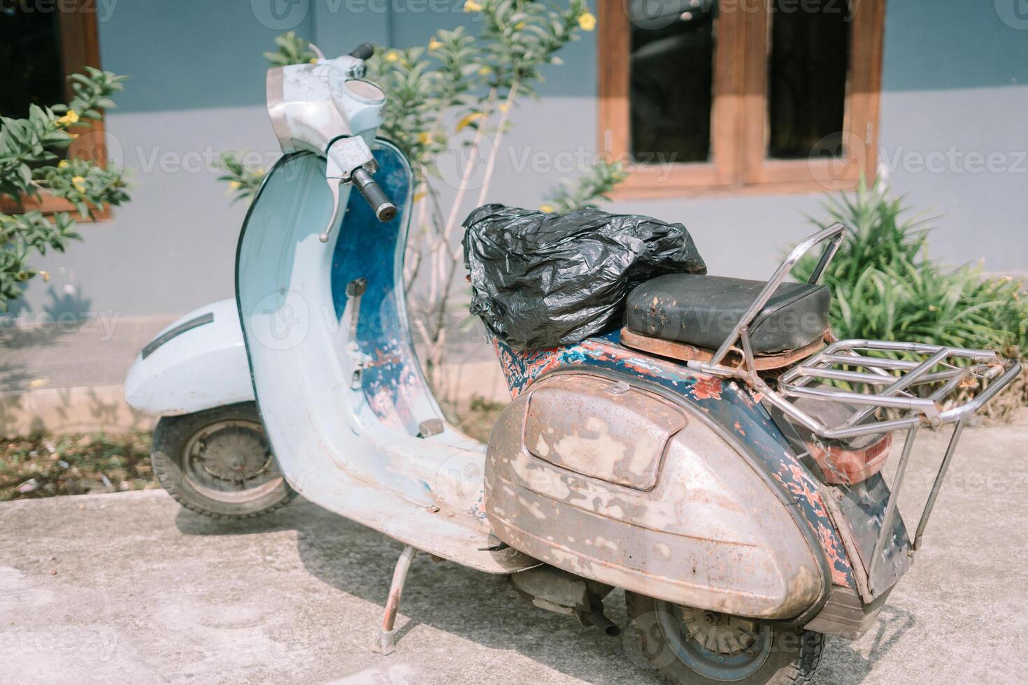 Vintage Vespa scooter showing signs of wear and tear, evoking nostalgia and character in an urban setting photo