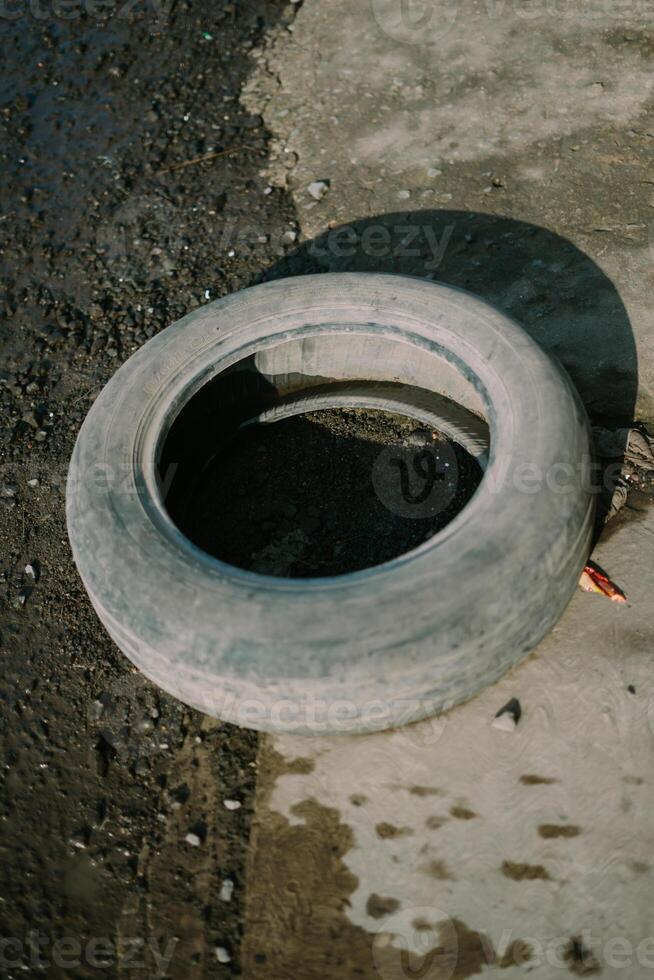 Old, used tire, showcasing signs of wear and tear, ideal for recycling or upcycling projects photo
