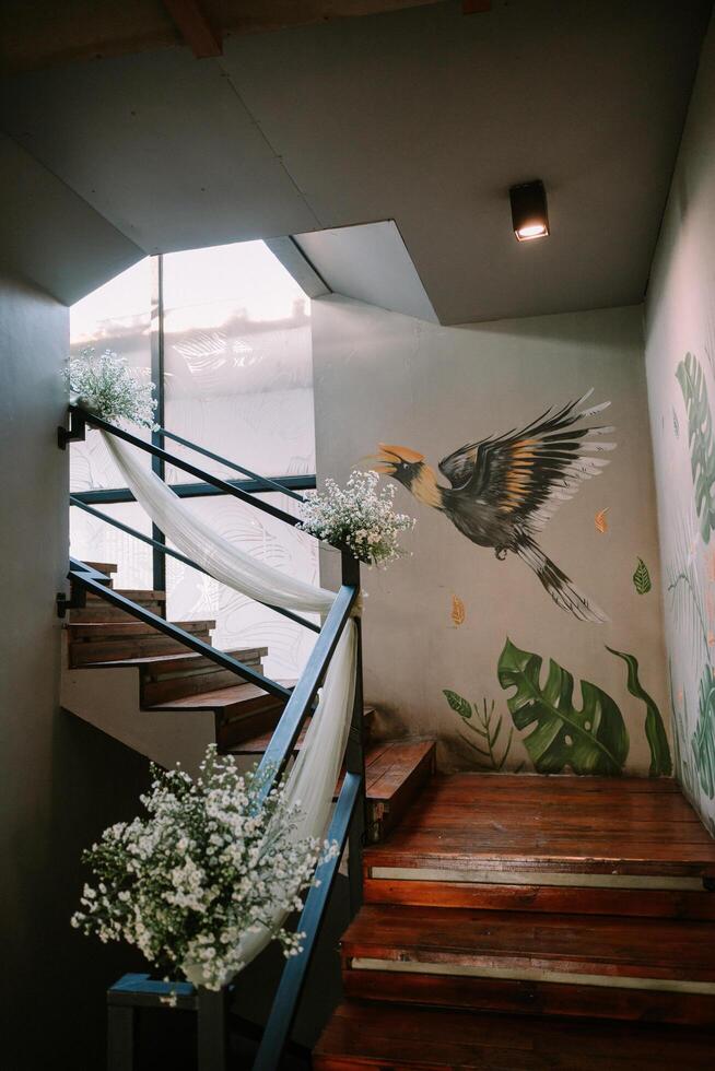 Bogor, June 21 2024. Upward staircase adorned with vibrant bird paintings and floral decorations, creating a whimsical ascent. photo