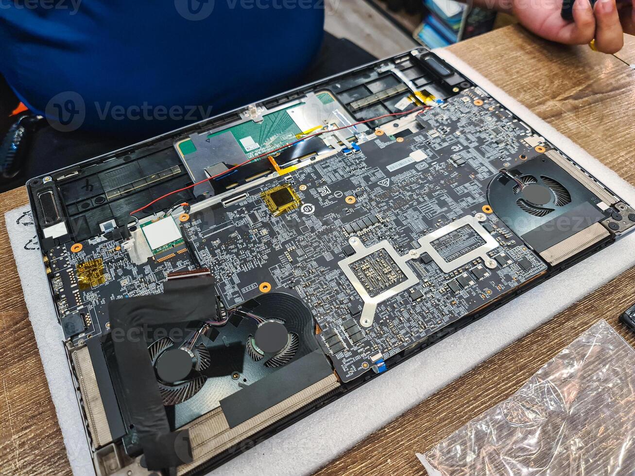 Computer technician disassembling mainboard with circuit of laptop repairing and upgrade technology photo