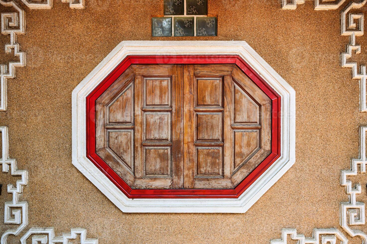 Wooden ancient oriental window on stone wall photo