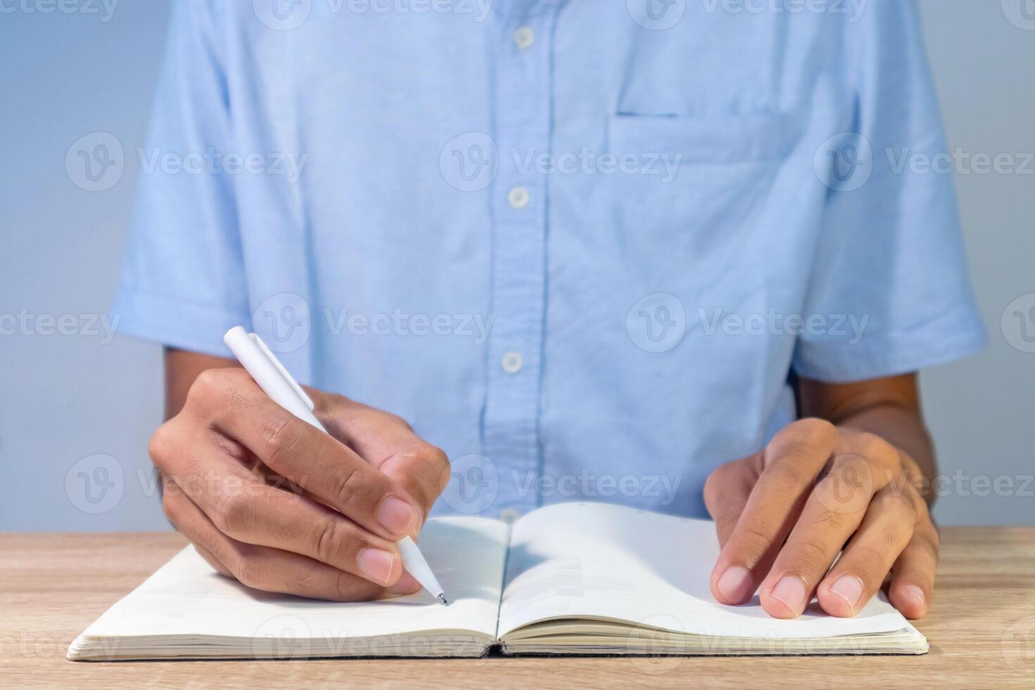 A man writing something at desk for notes, schedule and planning photo