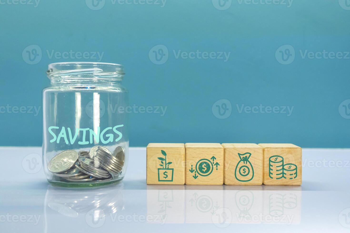 A glass jar filled coins and wooden blocks with savings or investment symbol concept. photo