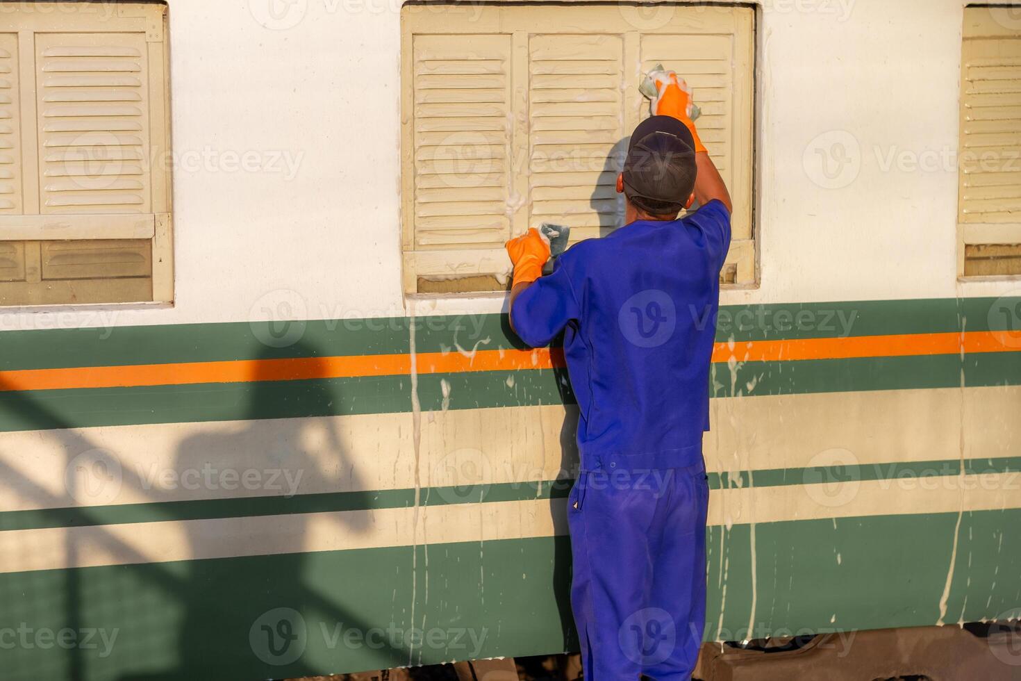 Employees are wiping, washing, inspecting and cleaning trains for use in transporting passengers photo