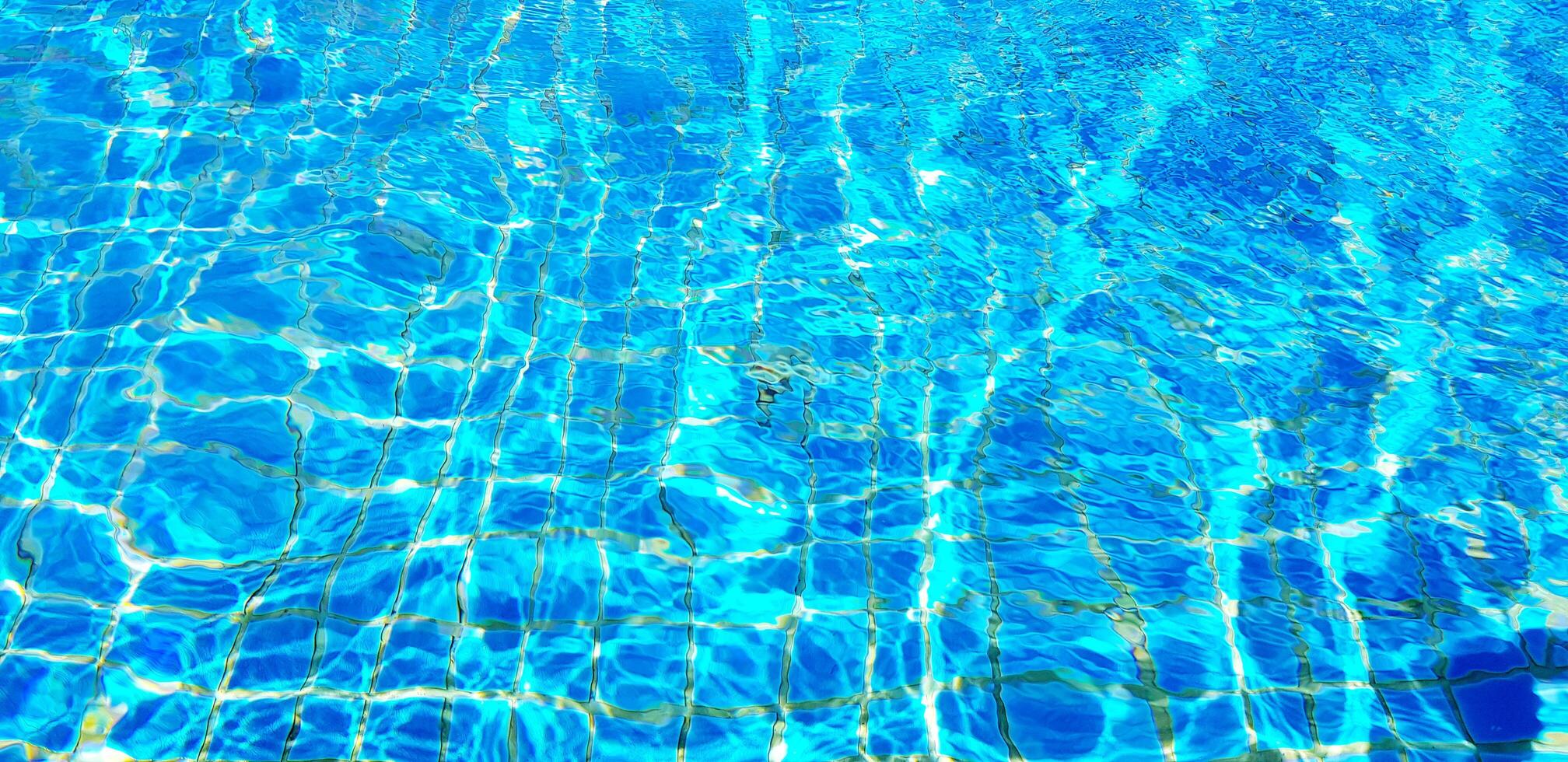 Wave or ripple water in swimming pool with sunlight reflection for background. Art or Abstract and Wallpaper concept. photo