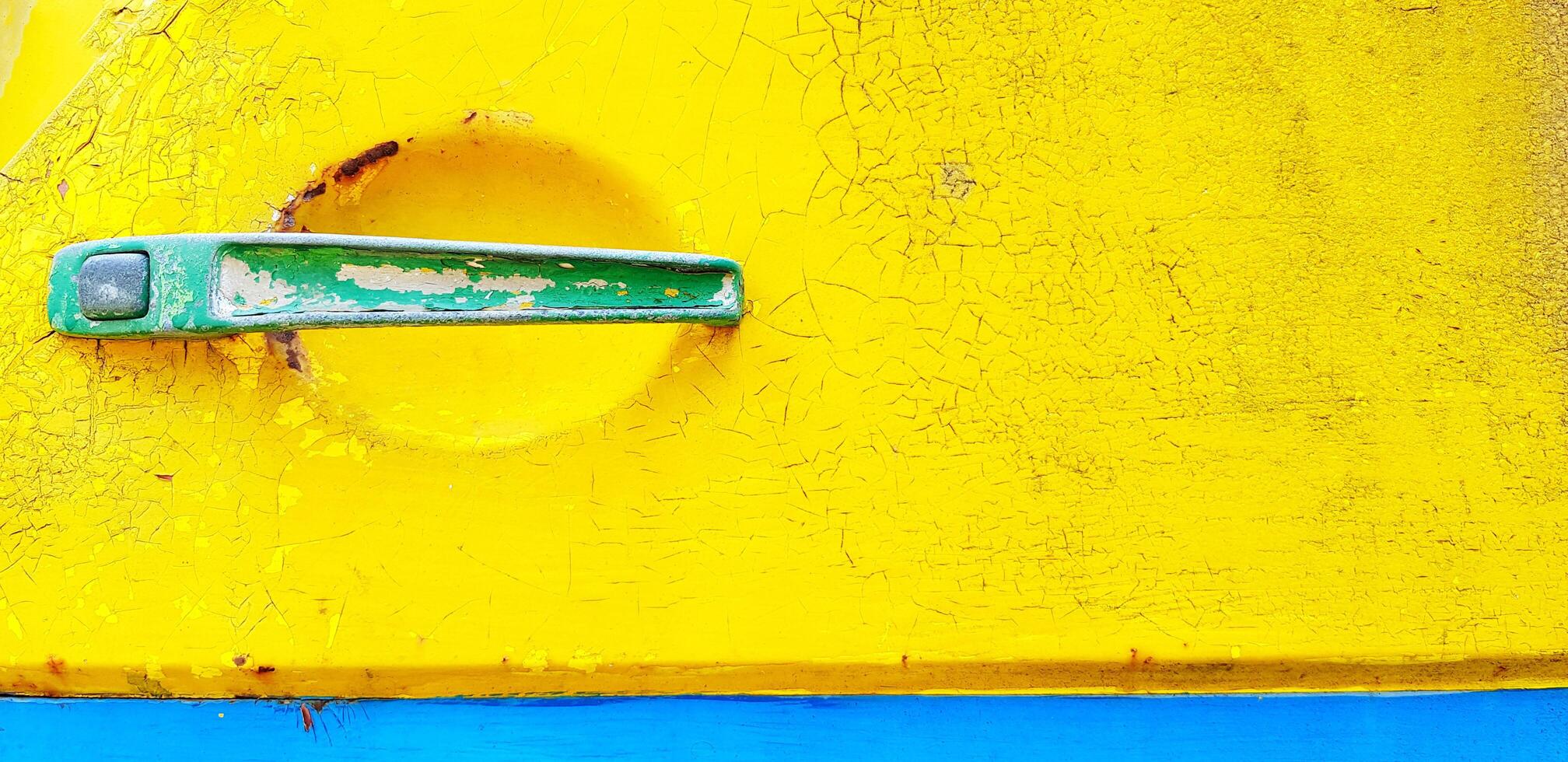 Close up old green handle of car door on grunge yellow background with copy space. Vintage object, Art and Colorful painting of wallpaper concept. photo