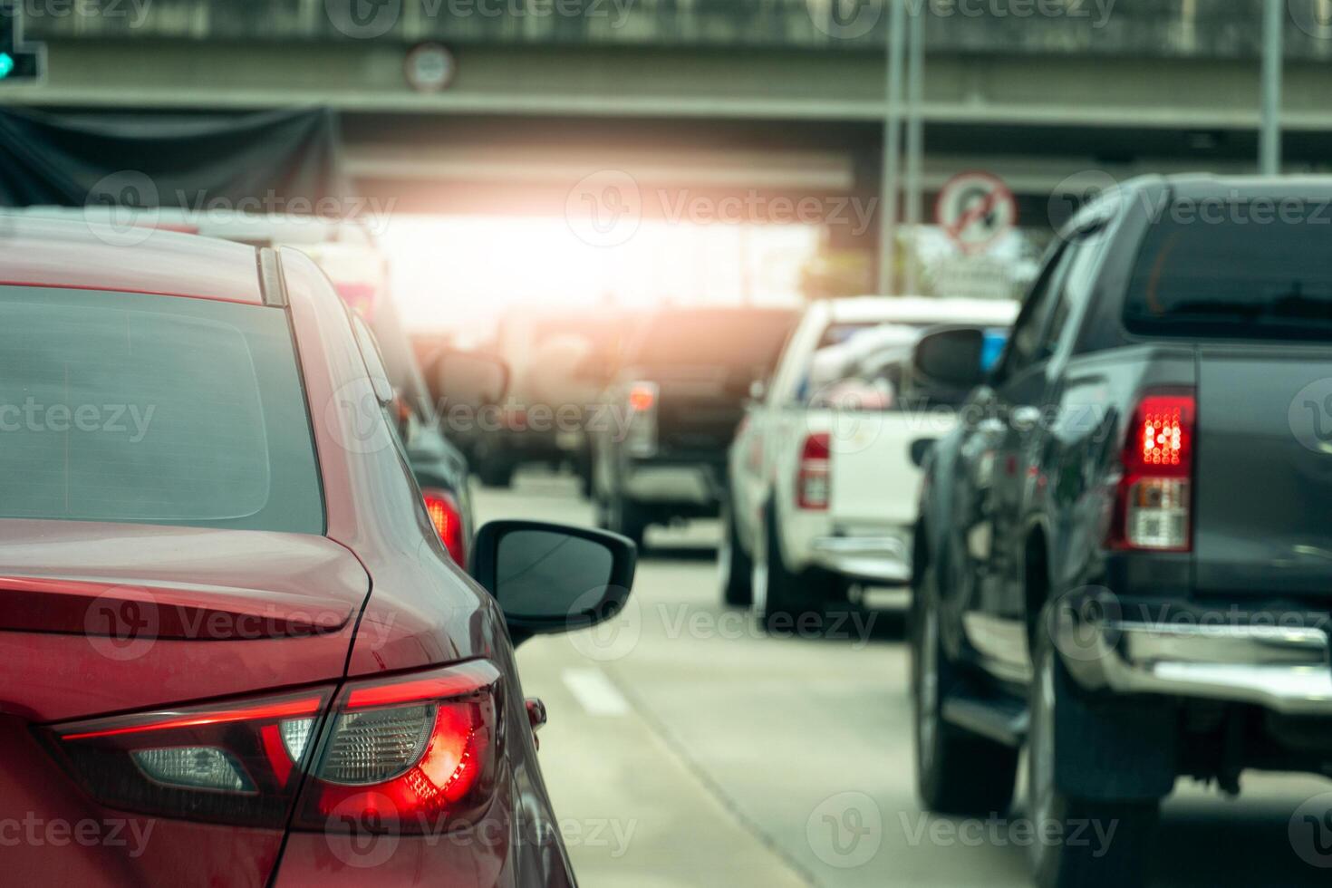 Luxury of red car stop on the road junction by traffic light control in across. Traveling in the provinces during the bright period. Open light brake. Concrete bridge crossing level intersection. photo