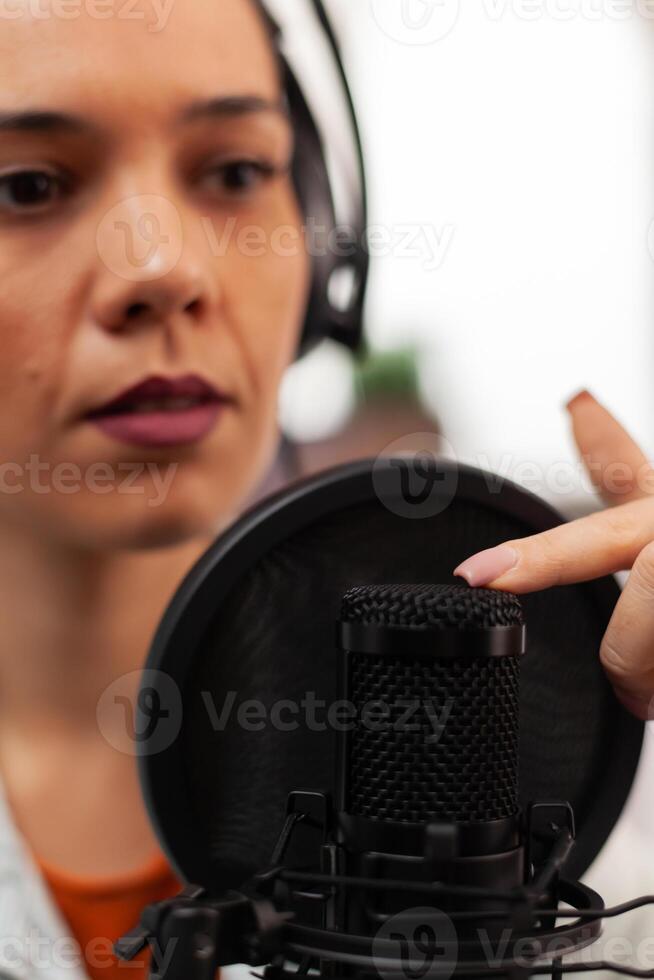 Blogger woman speaking about lifestyle in podcast using professional recording technology in home studio. Content creator making new serires for channel, streaming online broadcast on youtube photo