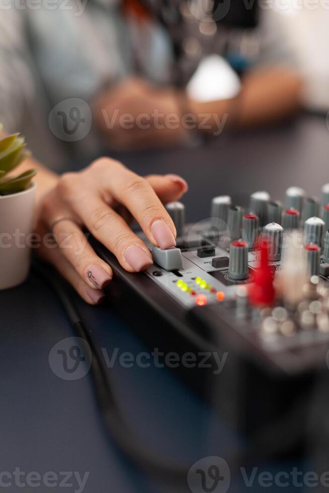 Close up of checking sound using mixer during online podcast. Social media influencer making professional content with modern equipment and digital web internet streaming station photo