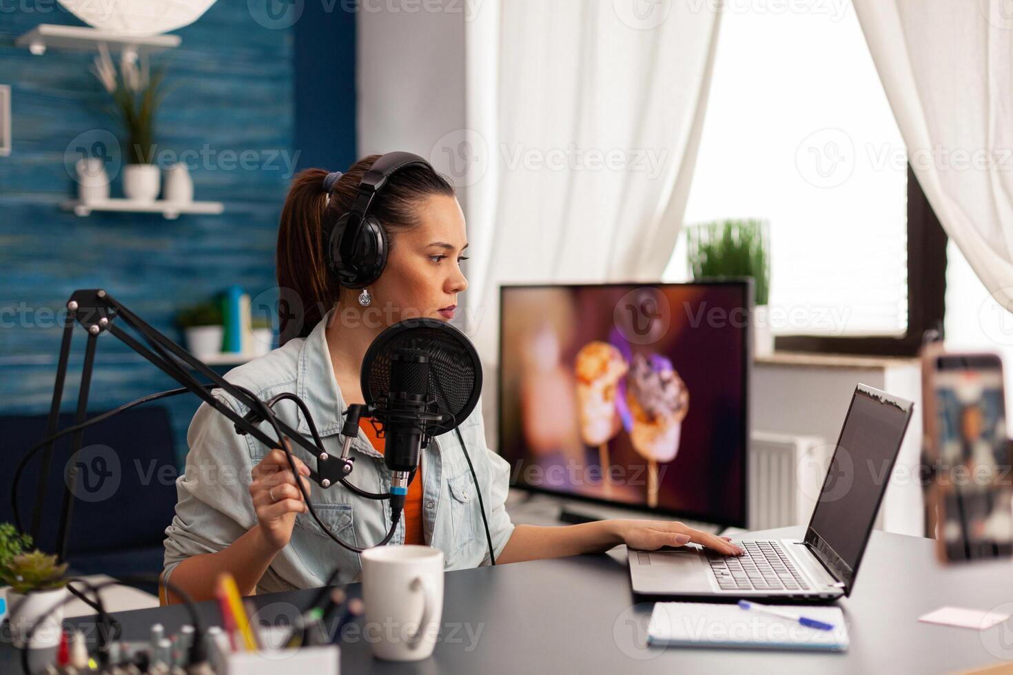 Creative vlogger making online conversation with her audience for new concept vlog. Recording social media content with production headphones, digital web internet streaming station photo