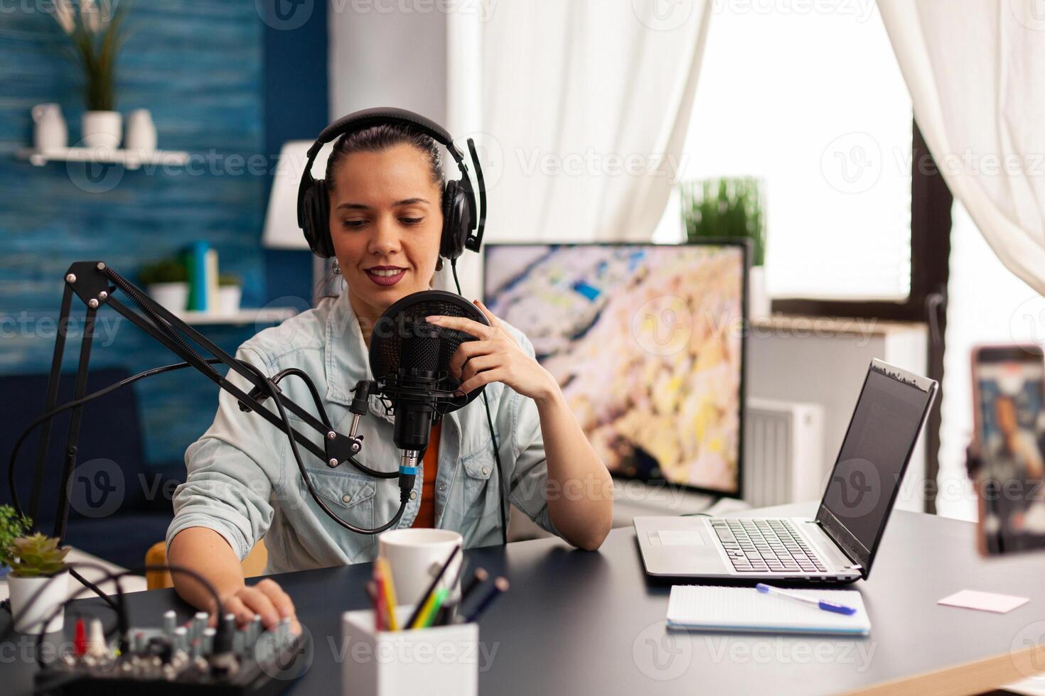 Vlogger recording blog with modern equipment in home studio podcast. New media star looking at camera for digital broadcast and having fun using technology to connect with audiences photo