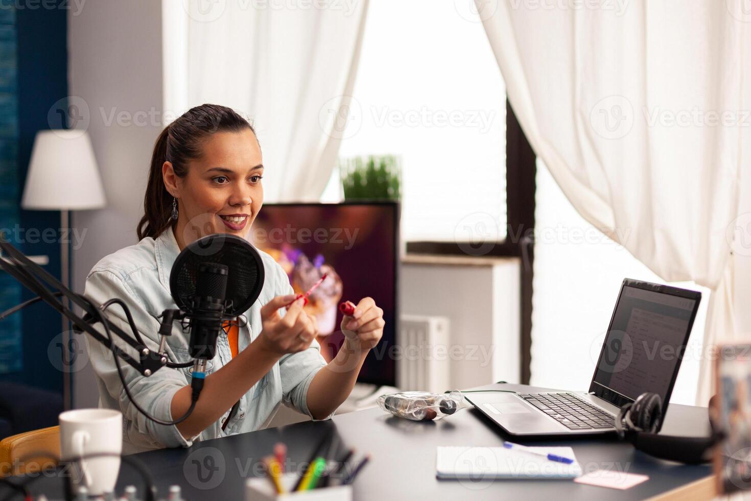 Beautiful vlogger making live make up tutorial share on social media using modern equipment. Influencer blogger sitting at the desk and recording blog where sharing advice for beauty community photo
