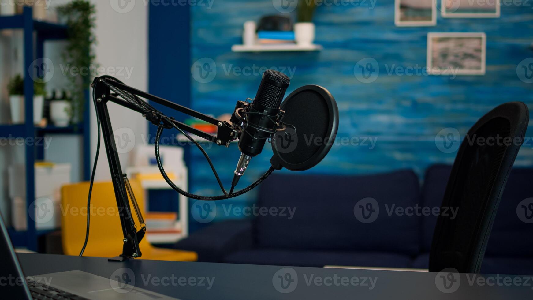 Station for recording and speaking during podcast in night in empty livin room studio. Influencer recording social media content with production microphone, digital web internet streaming station photo
