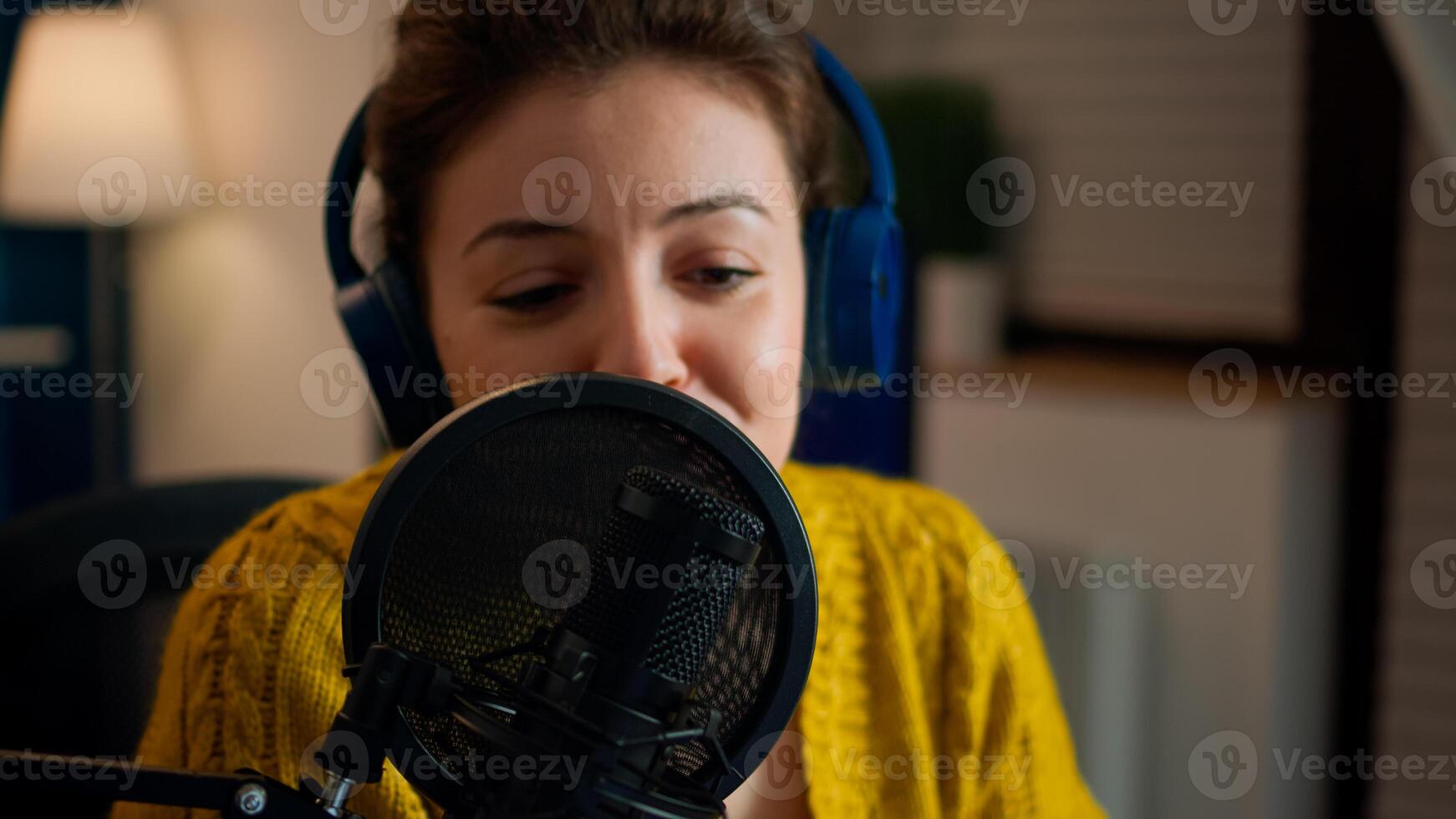 Influencer talking on professional microphone during livestreaming recording vlog in living room. On-air online production internet broadcast show host streaming live content for social media photo