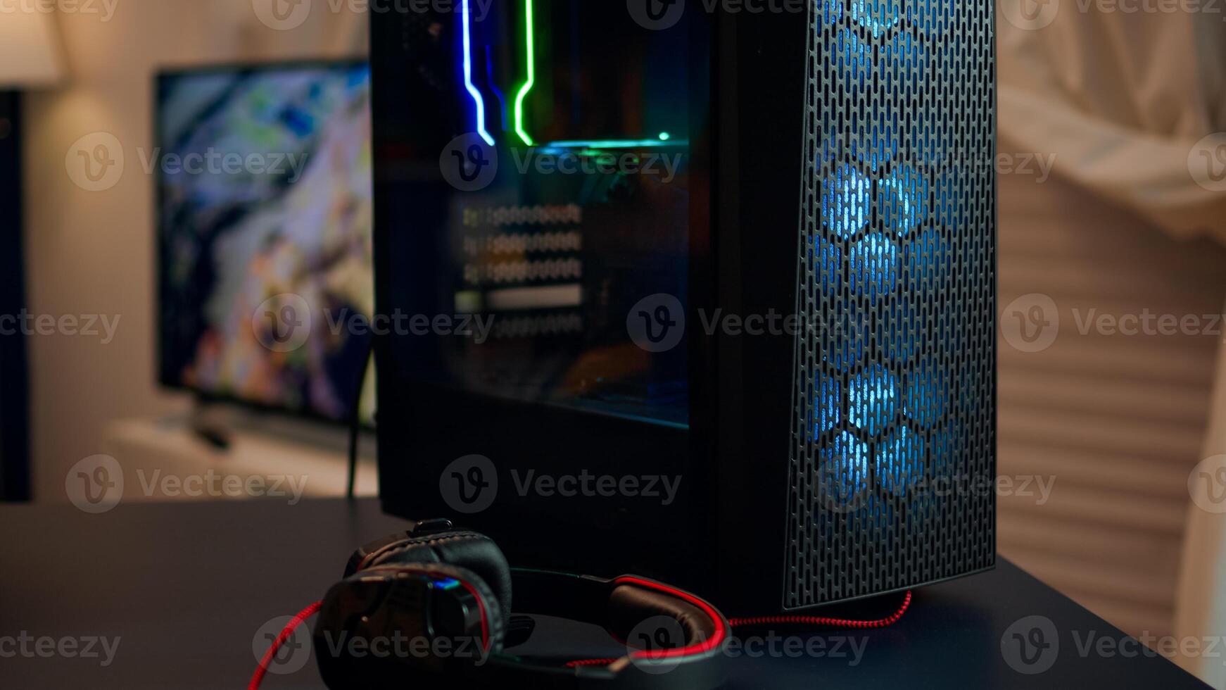 Powerful gaming unit with colorful RGB lights prepared for gaming tournament in living room at night. Cyber performing in stylish room playing online shooter game. photo