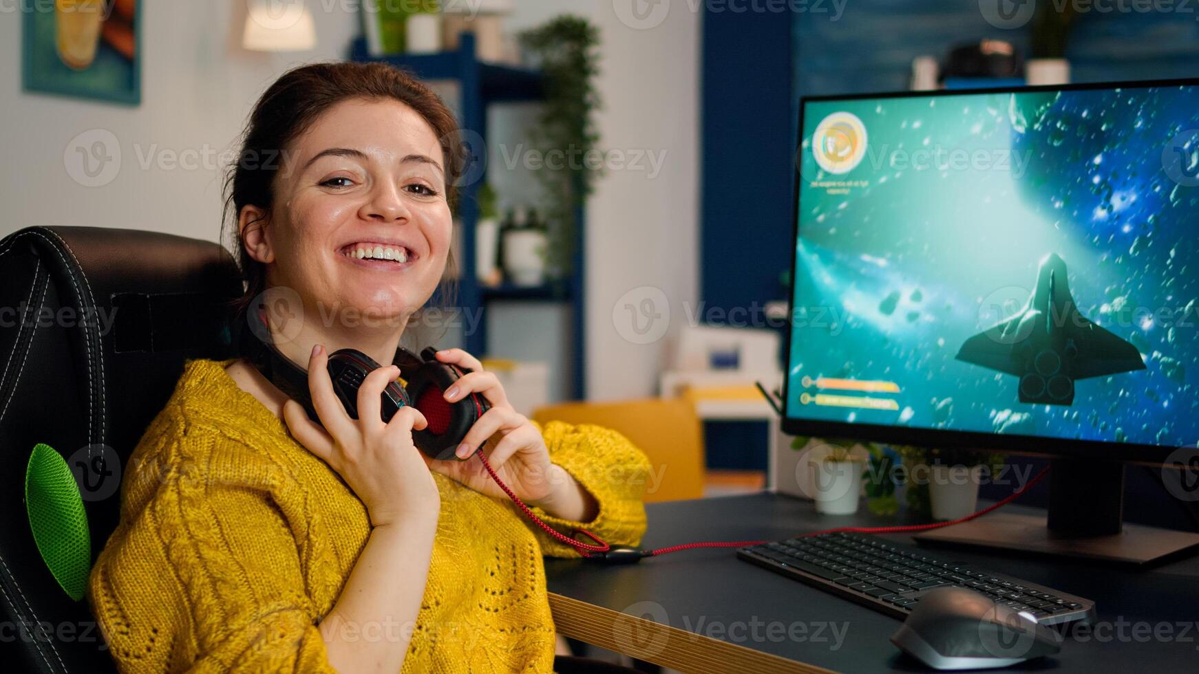 Concentrated gamer looking at camera while playing first-person space shooter online game on powerful computer spending loisure time at home. Esport cyber performing during gaming tournament photo