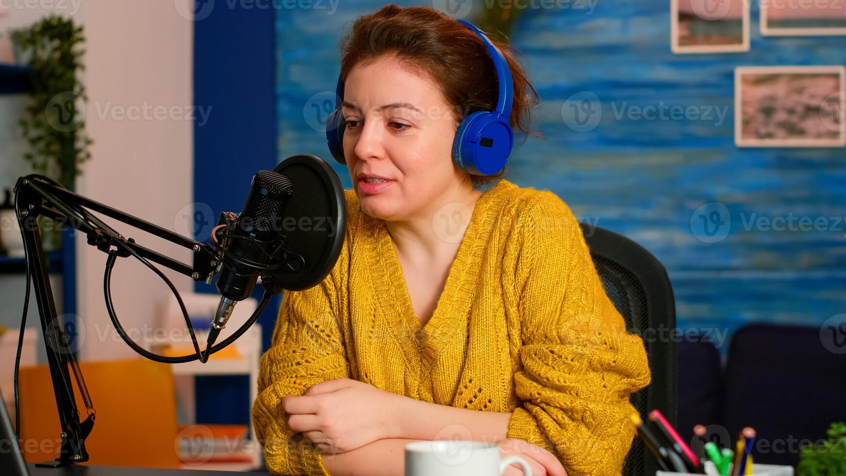 Famous influencer with headphones checking sound before live vlogging for social media, in home podcast studio. On-air online production internet broadcast show host streaming live content photo