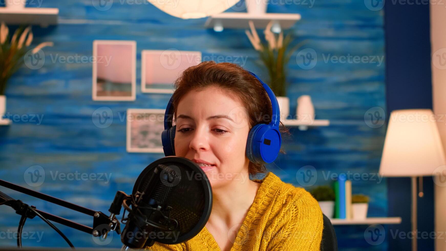 Influencer in entertainment industry talking and checking sound during broadcast from home studio at night. On-air online production internet podcast show host streaming live content for social media photo