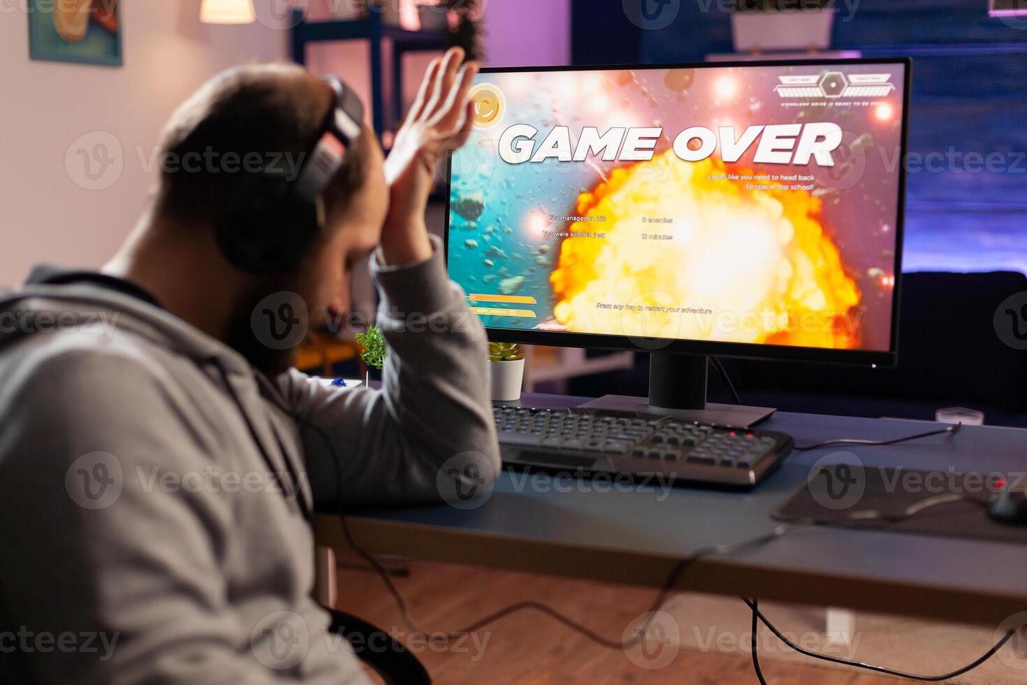 Portrait of sad upset gamer losing space shooter videogame. Defeated man with headphones streaming online cyber performing during gaming tournament using technology network wireless photo