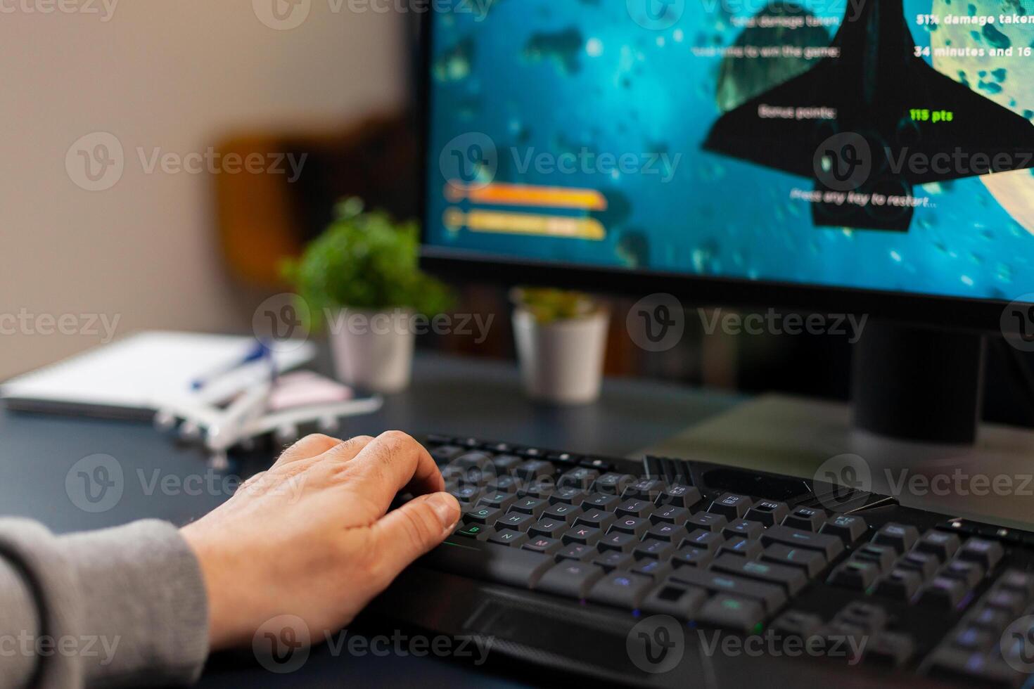 Hand of professional gamer on pro keyboard with RGB lighting during online gaming tournament. Home studio of esport game player using powerful gaming PC photo