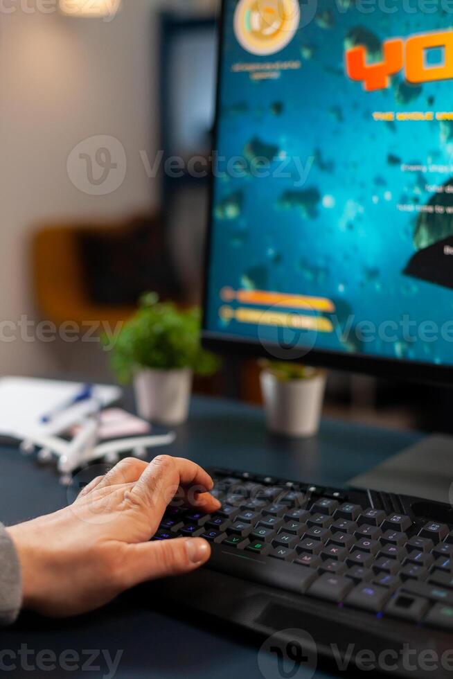 Close up hand of pro gamer during online tournament using RGB keyword streaming space shooter game photo
