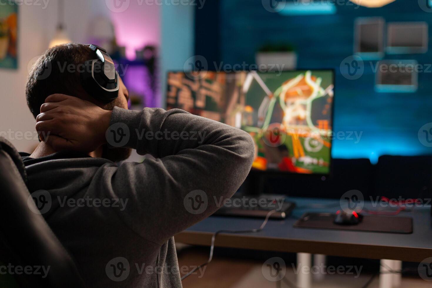 Competitive videogamer using powerful computer playing online videogame. Virtual streaming cyber streatching after performing gaming tournament using professional equipment. photo