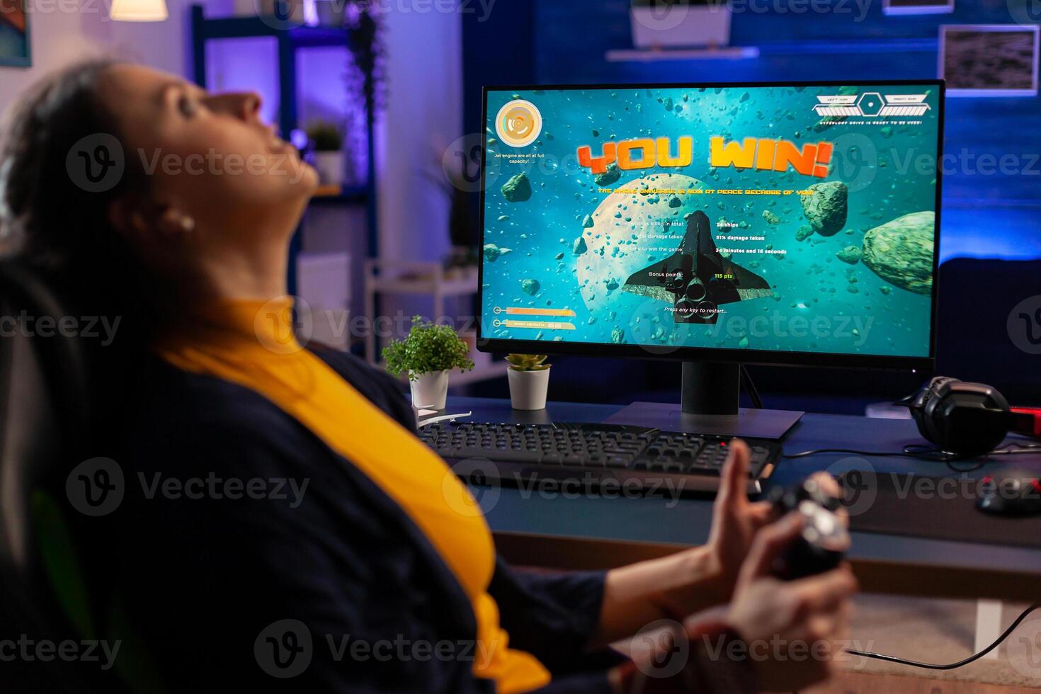 Gamer winning space shooter online tournament using professional controller and powerful computer. Pro player streaming online game new graphics in gaming home studio photo