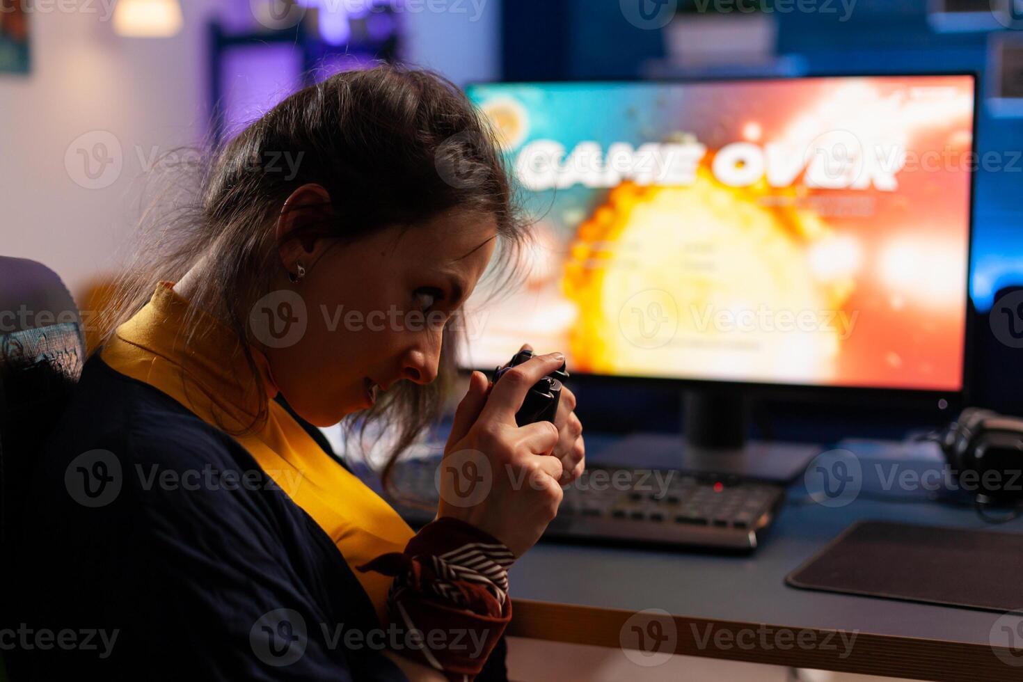 Game over for gamer playing games on powerful computer during night time in gaming studio at home. Woman streaming online videogames for esport tournament in room with neon lights photo