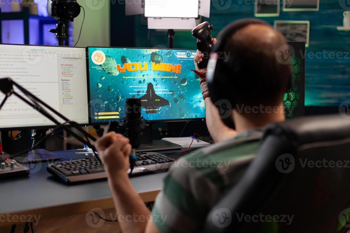 Streamer man talking with multiple players into headphones and winning games competition. Professional gamer streaming online videogames with new graphics on powerful computer from gaming room photo