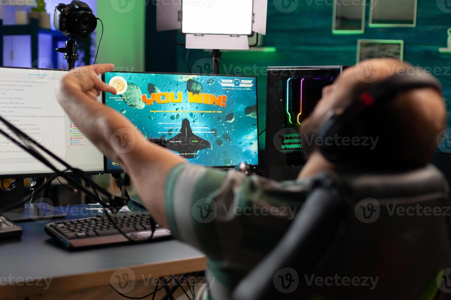 Concentrated streamer playing space shooter game using modern headset . Online streaming cyber performing on powerful professional computer during gaming tournament photo