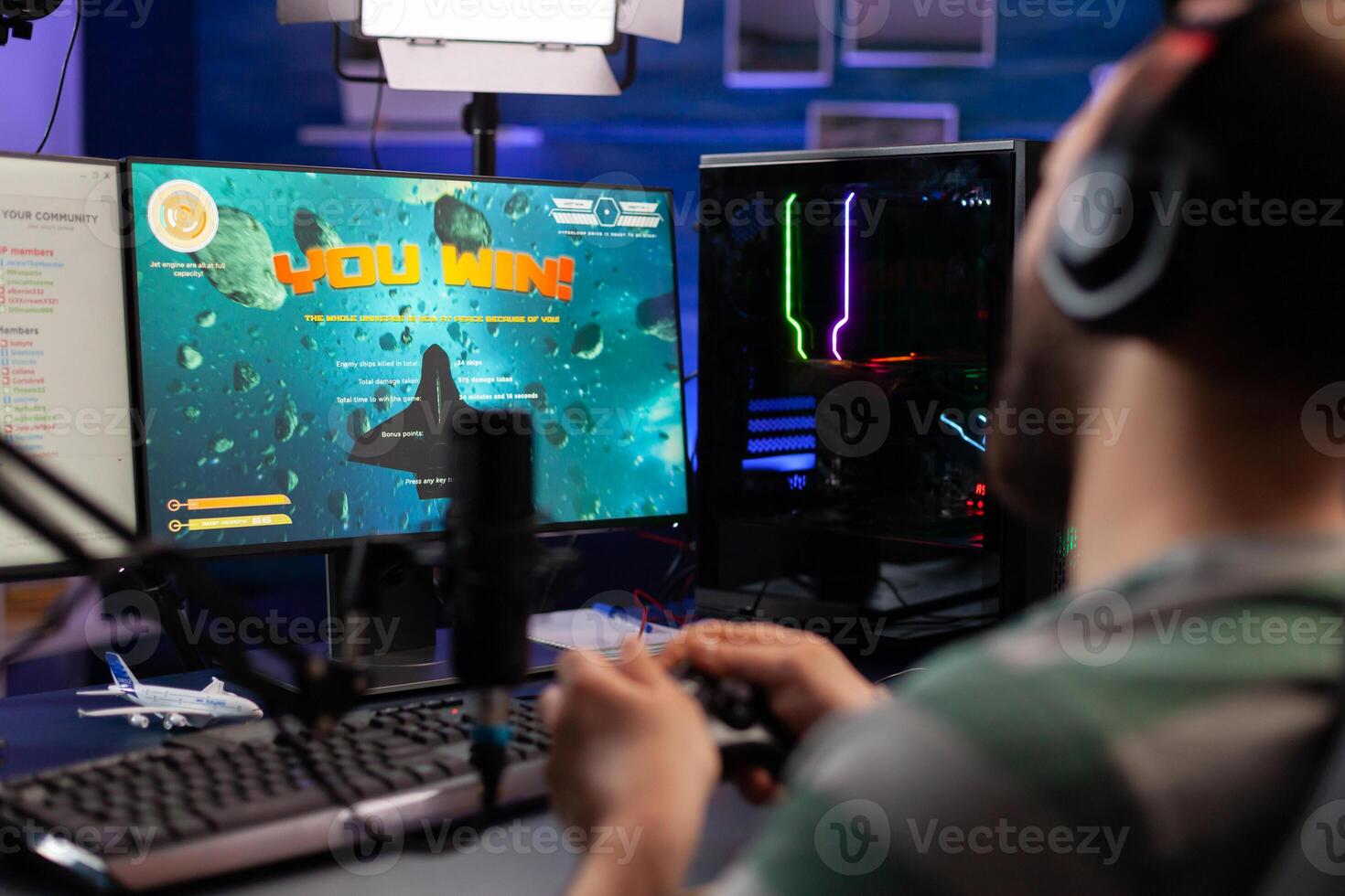 Excited streamer winning online virtual game competition of space shooter playing on powerful computer. Professional gamer using joystick for space shooter championship sitting on gamining desk photo