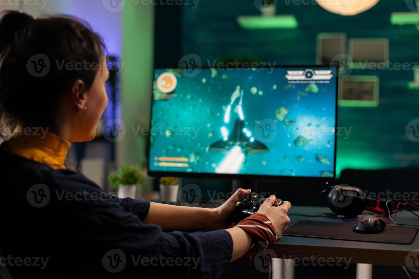 Caucasian woman holding wireless joystick and playing virtual videogames. Virtual streaming cyber performing live tournament using professional equipment in gaming home studio photo