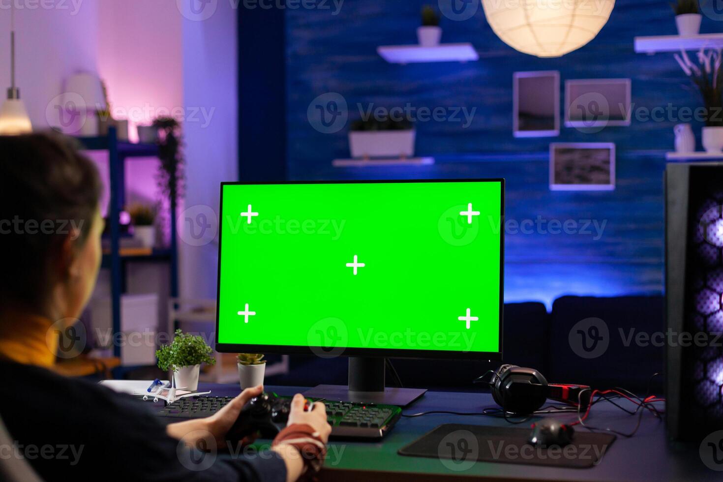 Competitive gamer looking into powerful pc with green screen display playing online games for live tournament. Cyber player using pc with mock up chroma isolated desktop streaming shooter games photo