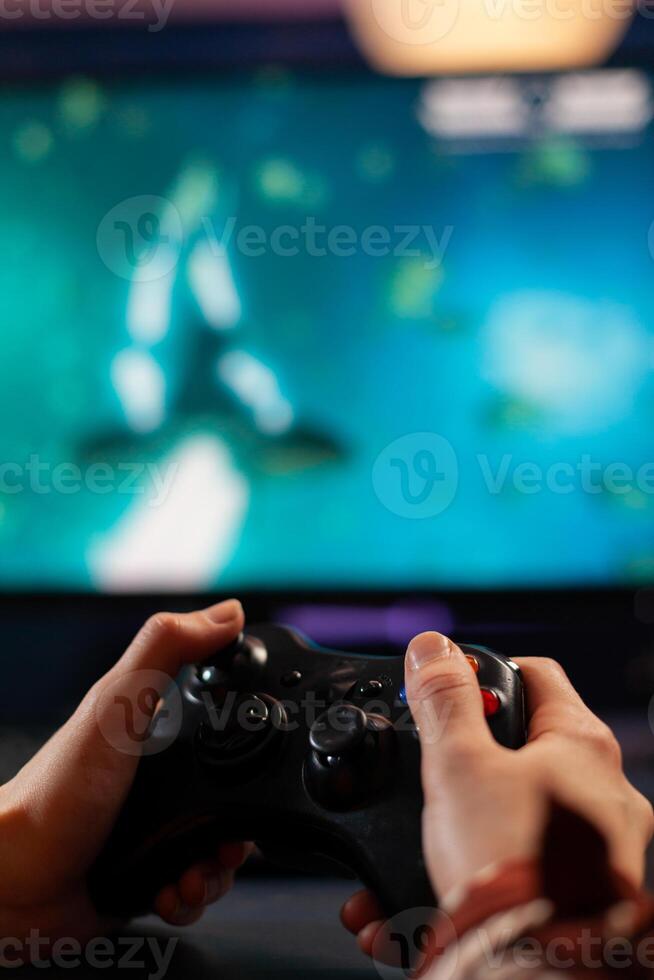 Close up of wireless joystick, gamer playing online videogames for live gamers tournament. Professional pro player streaming online game new graphics using powerful computer. photo
